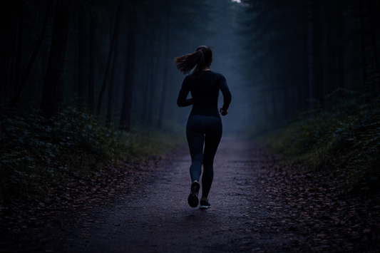 woman running on a dark trail at night